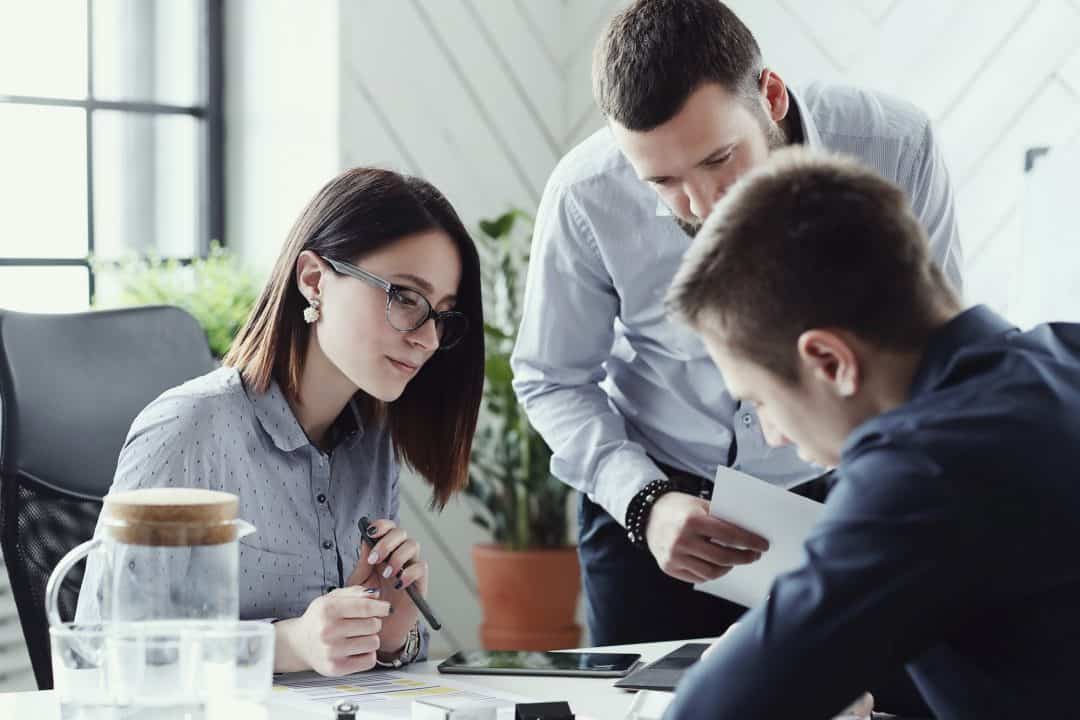 people looking at phone or tablet on a desk