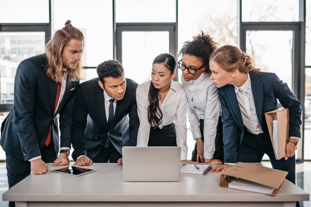 office employees all looking at each other and computer on the desk
